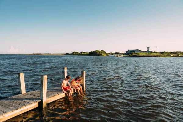 two boys sitting on a dock