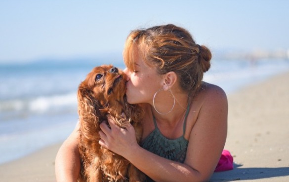 Woman kissing her dog on the beach | Sun-Surf Vacation Rentals Emerald Isle
