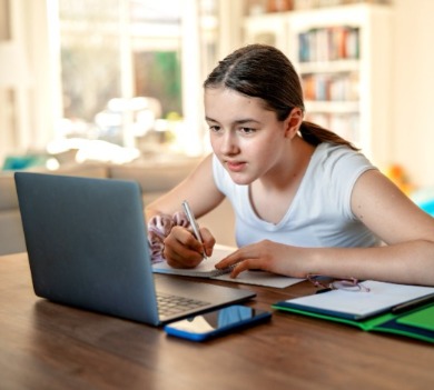 Teen girl doing schoolwork on laptop  | Sun-Surf Realty Emerald Isle Rentals